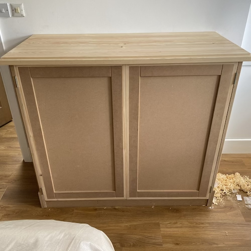 An unpainted, bespoke timber cupboard